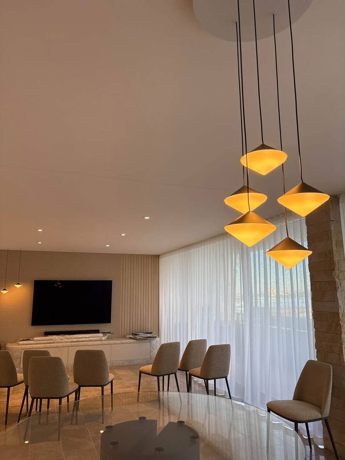 Cluster of glowing pendant lights over a dining table